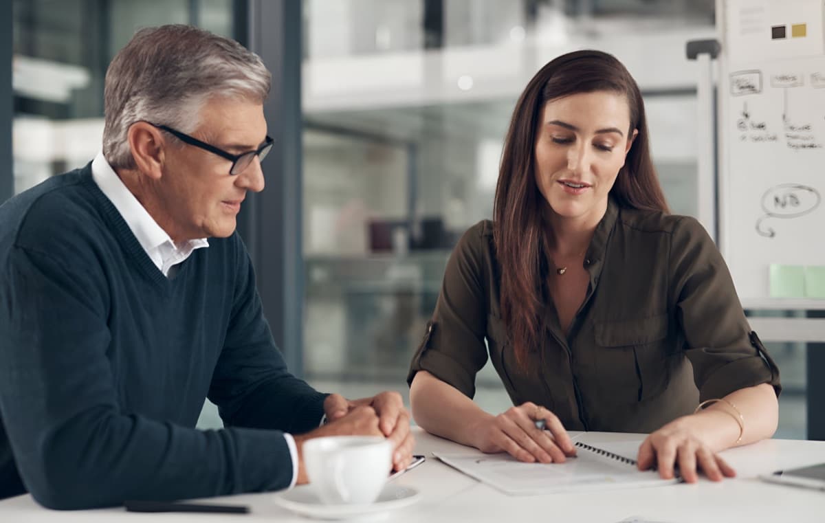 A tax professional reviewing paperwork with a client across a desk
